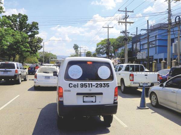 Vehículos estacionados a la derecha ocupan un carril frente al Seguro Social de San Pedro Sula.