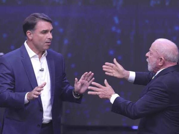 El presidente de Brasil y candidato a la reelección, Luiz Inácio Lula da Silva (d), y el opositor Flávio Bolsonaro, discuten durante el primer debate presidencial este domingo, en la sede de Rede Bandeirantes en Sao Paulo.