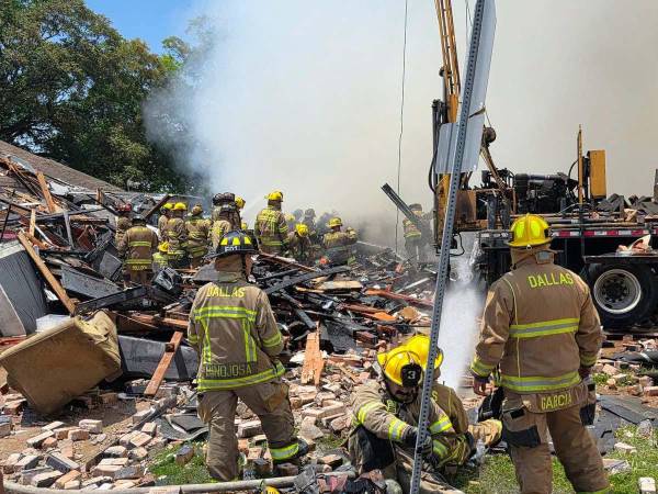Bomberos trabajan en la zona después de la explosión de gas natural que destruyó un edificio residencial en Oak Cliff.