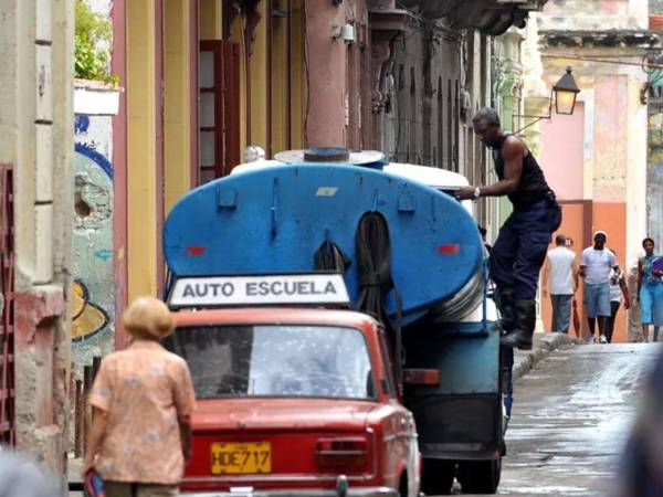 Fotografía de archivo de un obrero trabajando en un camión cisterna cargado de agua potable, en La Habana.