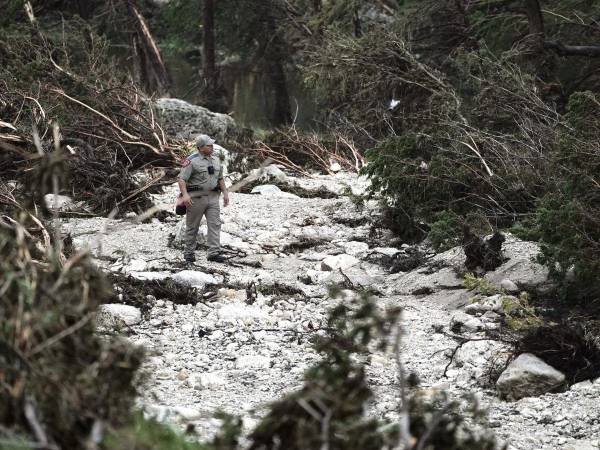 Un policía estatal de Texas participa en una búsqueda en una zona inundable, en Hunt, Texas.