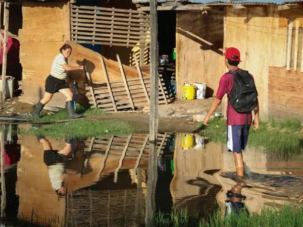 Un hombre camina en medio de una inundación en el barrio La Chacarita, a la orilla de la bahía de Asunción (Paraguay).