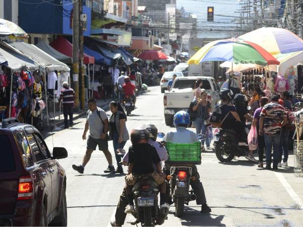Hondureños transitan por el centro de San Pedro Sula.