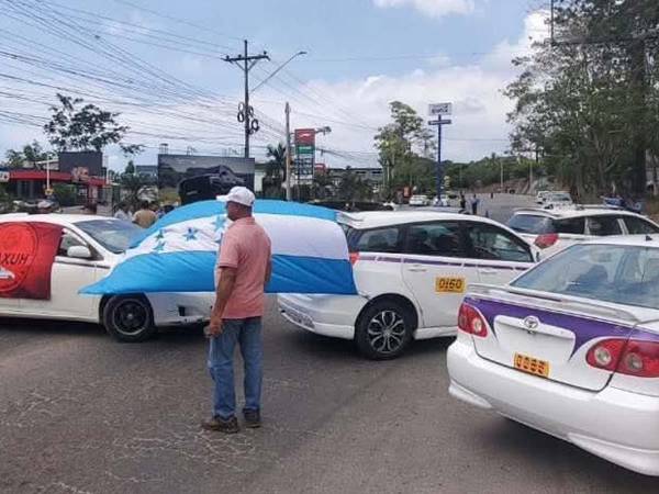 Taxistas de La Ceiba bloquearon la carretera CA-13 a la altura del puente Danto en protesta contra la posible legalización de plataformas digitales de transporte.