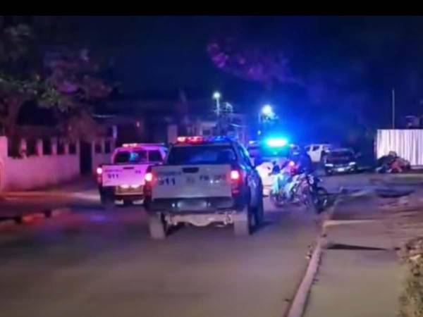Agentes de la Policía Nacional resguardan la zona donde se registró un enfrentamiento armado en San Pedro Sula, que dejó dos policías heridos y un supuesto criminal fallecido.