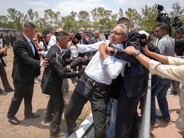 Momento en que un integrante de la Guardia de Honor Presidencial sujeta del cuello al periodista Edy Quintero durante la cobertura de un evento oficial en Tegucigalpa.
