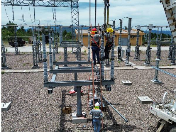 Trabajadores de la Enee instalan sistemas eléctricos en una subestación estatal.