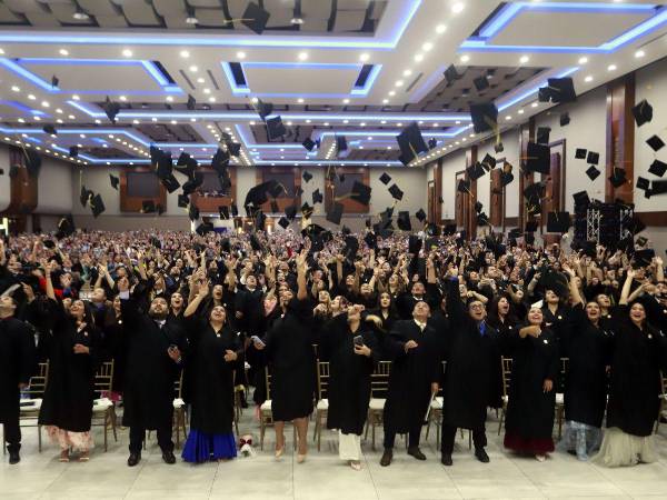 Los nuevos profesionales lanzaron el birrete al final de la ceremonia para celebrar su título universitario.