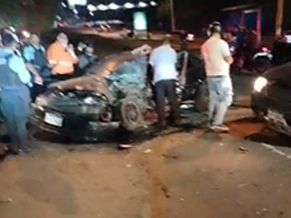 Bomberos trabajan en el rescate de personas atrapadas tras accidente en el anillo periférico, bajo el puente de El Trapiche en Tegucigalpa.