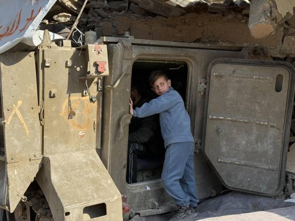 Rodeado de escombros a los pies de un edificio bombardeado por Israel, un tanque israelí abandonado en el barrio de Tel al Hawa, en la norteña ciudad de Gaza, sirve desde hace semanas de punto de carga para teléfonos móviles,.