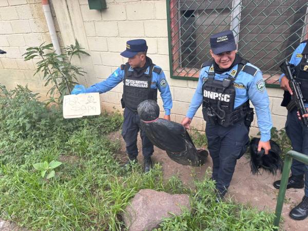 Policías de Honduras cargan el cadáver falso en Tegucigalpa.