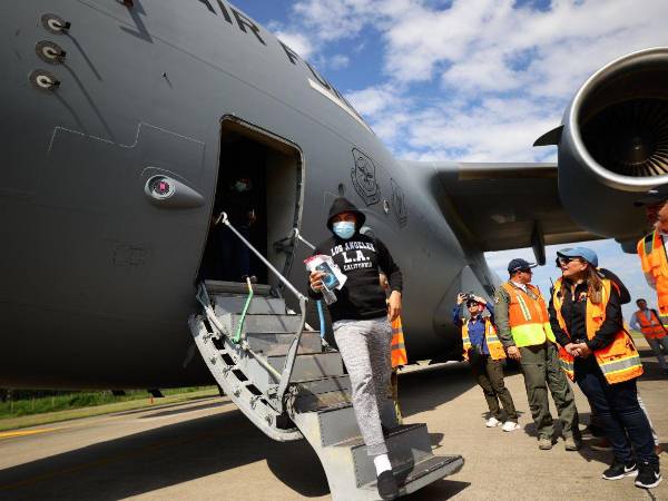 Un migrante hondureño se baja de un avión militar que Estados Unidos envió a Honduras.