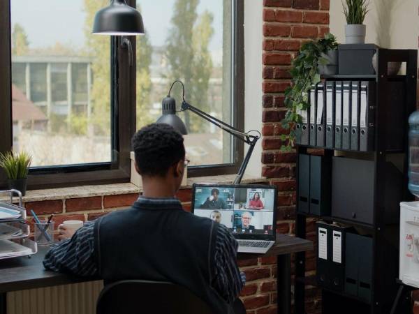 Un trabajador participa en una reunión de trabajo desde su casa.