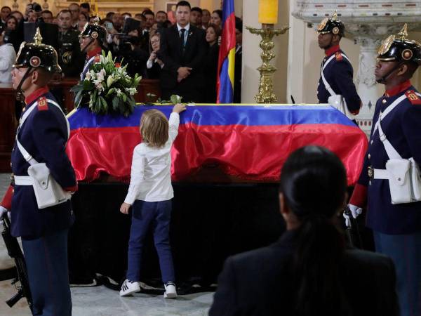El hijo del fallecido senador y precandidato presidencial Miguel Uribe Turbay, Alejandro, deja una flor sobre su féretro en una misa este miércoles.