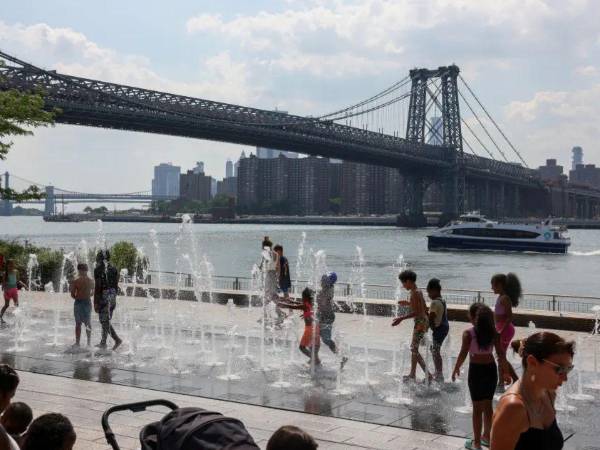 Un grupo de niños se refresca en en Brooklyn, Nueva York.