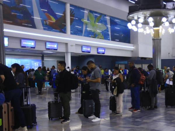 Pasajeros se forma en fila para hacer el proceso de Check-in en el aeropuerto Ramón Villeda Morales.