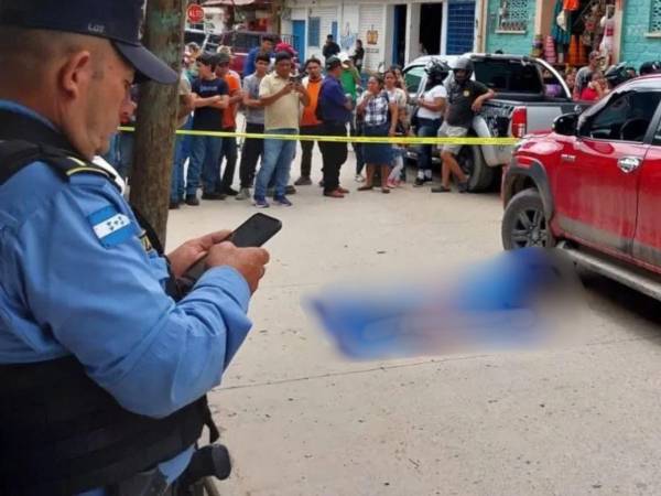 El cuerpo de la víctima quedó tendido al lado de un vehículo rojo.
