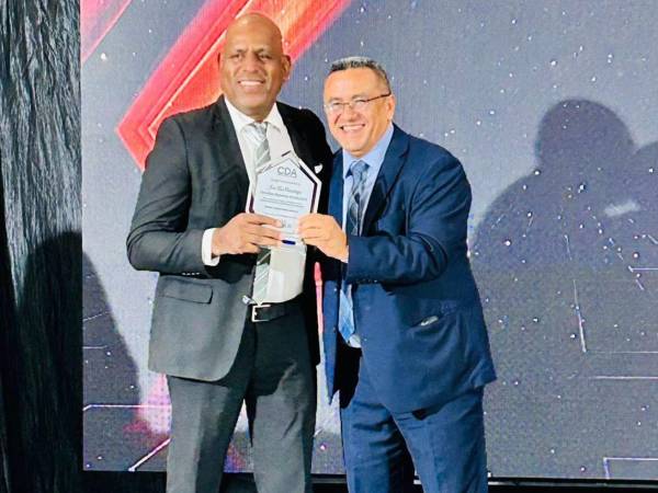 El periodista coloneño José Luis Barralaga recibe su placa de reconocimiento de manos de Rosel Matute.