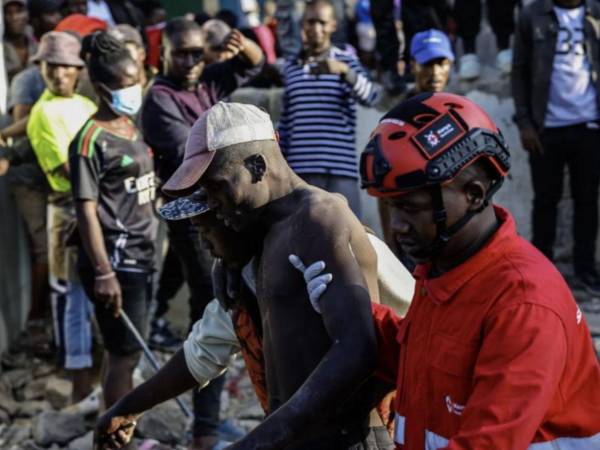 Un sobreviviente, herido, es llevado a una ambulancia tras ser rescatado de los escombros del edificio que se derrumbó en Nairobi hoy 16 de marzo de 2026.