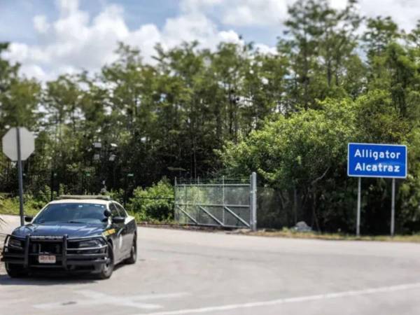 Un coche de polícia en la entrada del centro de migrantes 'Alligator Alcatraz'.