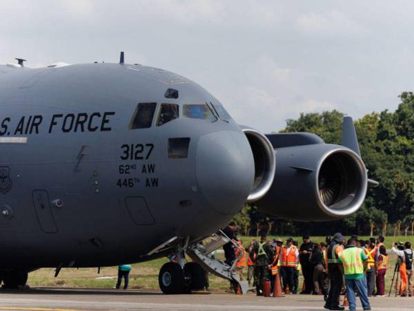 Un grupo de hondureños deportados descienden de un avión militar estadounidense en el aeropuerto Ramón Villeda Morales de San Pedro Sula, norte de Honduras.