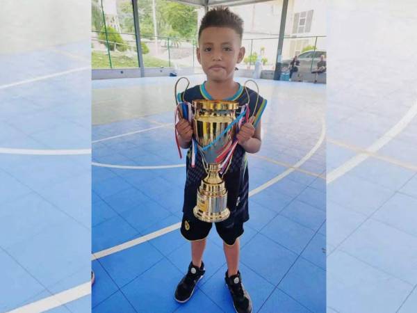 Elvis Eliú Bautista con el trofeo que conquistó cuandojugaba baloncesto.