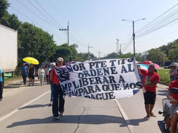 Protestantes llevan manta con leyenda Señor presidente Tito Asfura ordene al MP liberar a Iván para que nos pague.