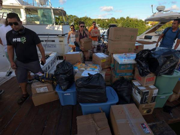 Personas cargan paquetes con ayuda humanitaria para un barco que zarpará hacia Cuba desde Isla Mujeres, en Quintana Roo (México).