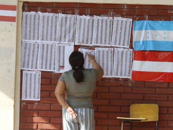 Una hondureña busca en el listado electoral en una escuela de San Pedro Sula, durante las elecciones primarias 2025.