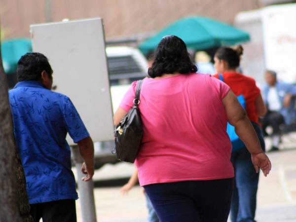 Un grupo de personas camina por la calle en una fotografía de referencia.