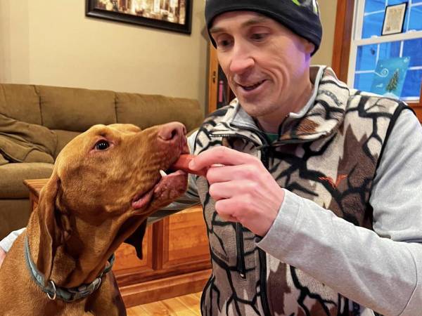 Chad Tavernia, que se especializa en encontrar mascotas perdidas, con Otis tras ser reunido con su familia en el 2024. (North Country Drone Search &amp; Recovery)