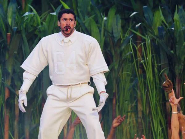 El atuendo de Bad Bunny consistía en dos piezas monocromáticas de camisa con cuello y corbata y al estilo de jugador de fútbol americano con el dorsal 64, pantalones y zapatillas Adidas.