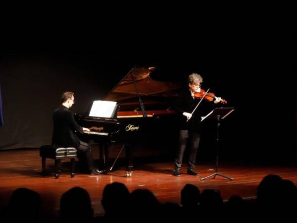 Los artistas Calio Alonso (piano) y Pablo Martos (violinista) durante su presentación musical en dúo.