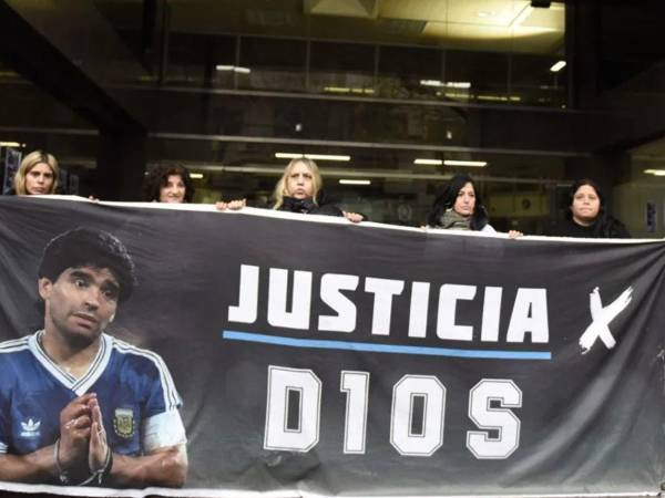 Varias personas que sostienen un cartel con la imagen de Diego Armando Maradona durante el juicio por la muerte del futbolista argentino en Buenos Aires, Argentina.