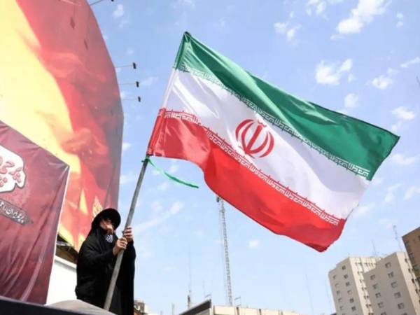 Fotografía de archivo de una mujer sosteniendo la bandera de Irán, en <a rel=noopener noreferrer href=https://www.laprensa.hn/mundo/iran-establecera-proximos-dias-zona-restringida-fuera-estrecho-ormuz-AP31949180 target=_blank>Teherán</a> (Irán).