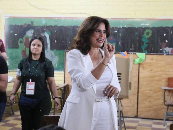Rixi Moncada muestra a las cámaras su dedo meñique tras votar en la residencial Centroaméroica Oeste.