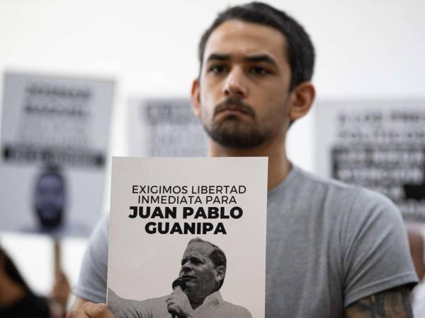 Ramón Guanipa sostiene un cartel de su padre detenido, Pedro Guanipa, en una imagen reciente.