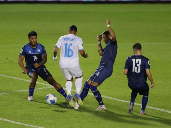 Edwin Rodríguez es frenado por dos zagueros de Nicaragua.