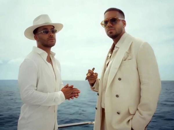 Captura de video cedida por Sony Music Latin que muestra a los cantantes Prince Royce (i) y Romeo Santos (d), durante el video de la canción 'Better late than never'.