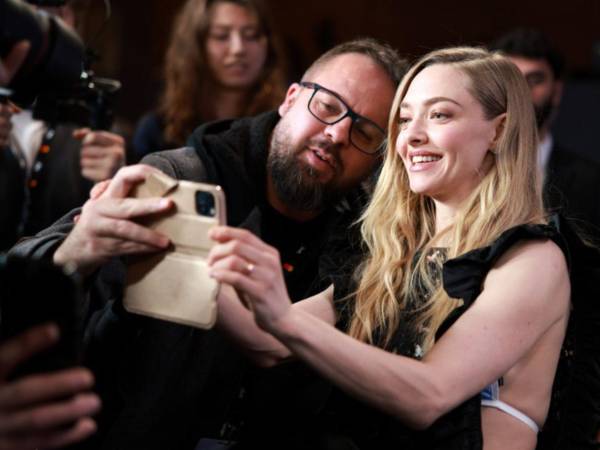 La actriz estadounidense Amanda Seyfried se toma un selfie con un fan y miembro de la prensa al final de una conferencia de prensa para 'The Testament of Ann Lee' durante el 76º Festival Internacional de Cine de Berlín, en Berlín, Alemania.