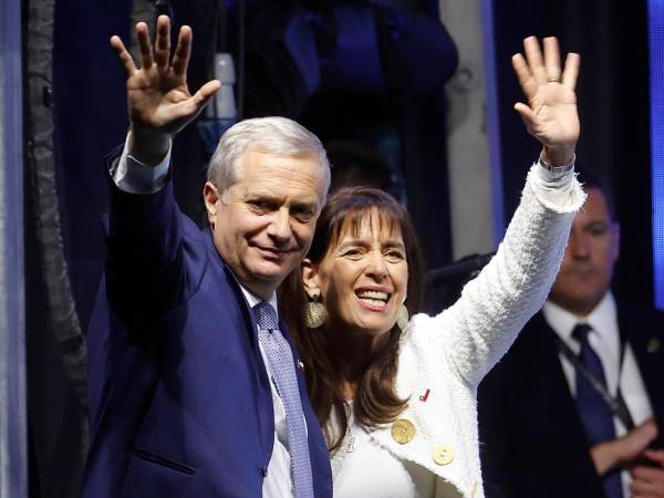 El presidente electo de Chile, el ultraderechista José Antonio Kast, saluda junto a su esposa, María Pía Adriasola, tras ganar la segunda vuelta de las elecciones presidenciales este domingo, en Santiago (Chile).