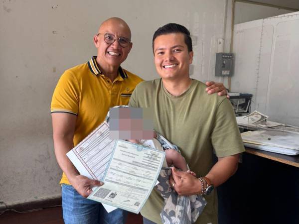 Los dos felices padres muestran al bebé que se registró con dos padres. Los dos papá del bebé son extranjeros que radican en Nuevo León, México.