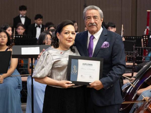 Blanca Echeverry recibió el diploma de reconocimiento de manos de Rafael Flores, presidente de la Fundación Filarmónica de San Pedro Sula.