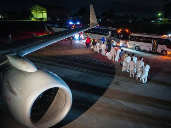 Fotografía cedida por la Cancillería de Colombia que muestra a ciudadanos colombianos caminando para ser trasladados en buses tras ser deportados desde Estados Unidos.