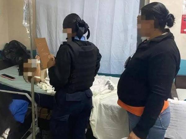 Fotografía de la mujer cuando era asistida en el hospital y era resguardada por agentes policiales.