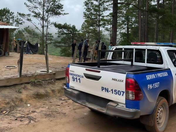 Patrulla de la Policía Nacional en el lugar donde ocurrió el triple crimen.