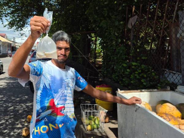 Ángel Meléndez dejó el taxi por la crisis del rubro y ahora vende agua de coco en el barrio El Imán, en La Ceiba.