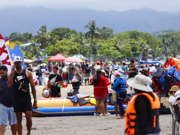 Familias se instalan desde temprano en la arena para compartir y disfrutar del ambiente playero en Puerto Cortés.