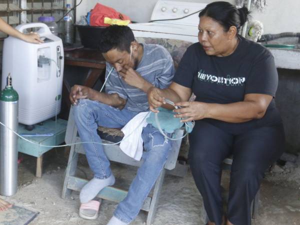 Madre de Denis Omar hace cambio del concentrador de oxígeno al cilindro portátil debido a que un apagón dejó sin energía la zona mientras el equipo de LA PRENSA realizaba una visita a su hogar.
