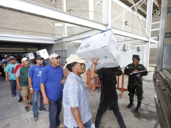 Personal contratato por el Consejo Nacional Electoral (CNE) descarga material electoral de San Pedro Sula en el Ginmasio Olímpico.
